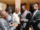 District Commissioner of Eldoret Christopher Wanjau and County Secretary Phillip Arap Meli receive DVD copies of 'An African Answer' from Pastor James Wuye and Imam Muhammad Ashafa. Joseph Wainaina is third from left.