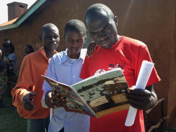 Youth receive the Resource Guide that accompanies the film 'An African Answer'
