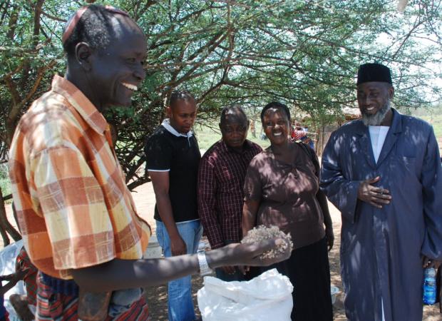 Joseph Kwopin with grass seed. Imam Muhammad Ashafa looks on. 