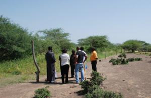 RAE Trust staff show the USIP/IofC team the difference between protected pasture (left) and land open to communal grazing. The latter is prone to erosion by wind and flash floods. (Photo: Alan Channer)