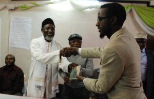 Abdi Yarow, Centre for Ihsan Education and Development, receives an Arabic DVD of 'The Imam and the Pasto' from Imam Muhammad Ashafa and Pastor James Wuye (Photo: Alan Channer)