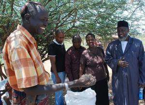 Joseph Kwopin with grass seed. Imam Muhammad Ashafa looks on. (Photo: Alan Channer)