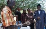 Joseph Kwopin with grass seed. Imam Muhammad Ashafa looks on. 